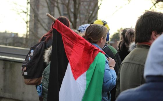 صورة لمتظاهرة تحمل علم فلسطين