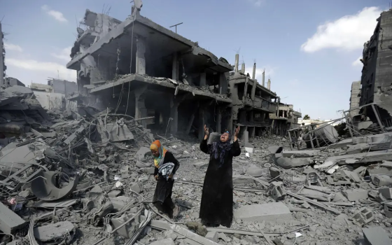 صورة لامرأة وفتاة بين البيوت المهدمة في غزة جرّاء قصف الاحتلال الإسرائيلي