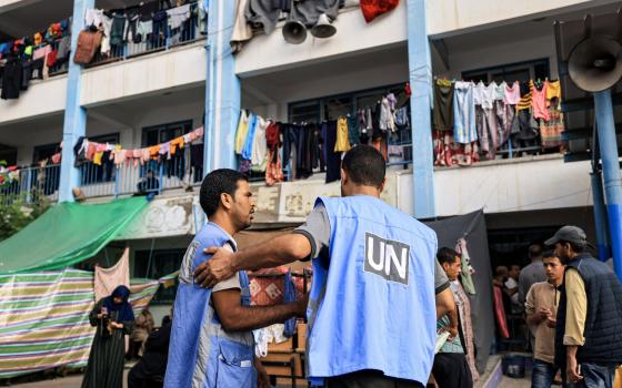 موظفون من الأونروا في مدرسة مزدحمة بالنازحين