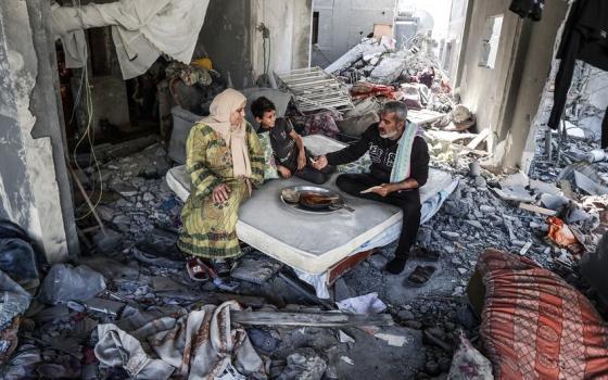 عائلة تتناول الطعام فوق ركام منزلهم