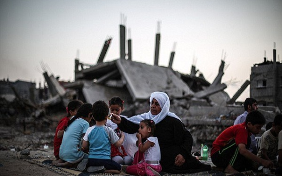 عائلة تتناول الطعام فوق ركام منزلهم