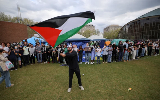 طالب يحمل العلم الفلسطيني أمام تحرك طلابي تضامني