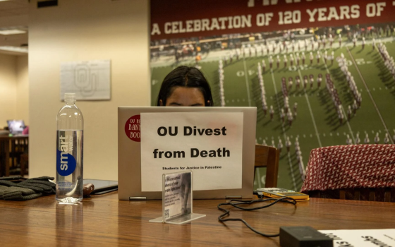 طالب يعلق ورقة بجملة تضامنية في دراسة صامتة لأجل فلسطين