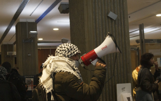 طالب داعم لفلسطين يستخدم مكبر صوت ليهتف بشعارات تضامنية