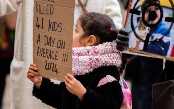 طفلة تحمل لافتة تضامنية خلال مظاهرة في كارديف