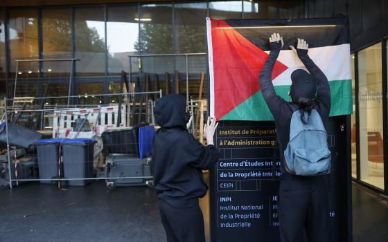 طالب يعلق العلم الفلسطيني  