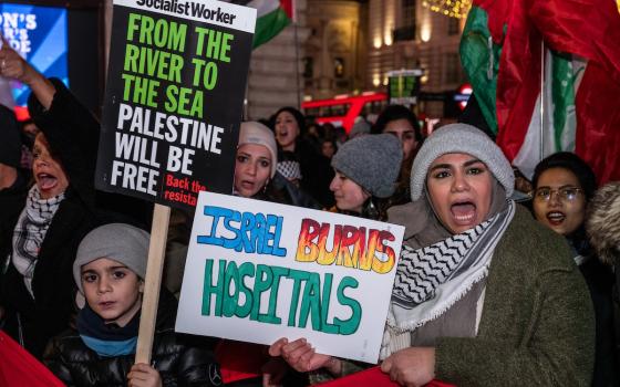 متظاهرة تهتف وتحمل لافتة تدين قصف الاحتلال للمستشفيات