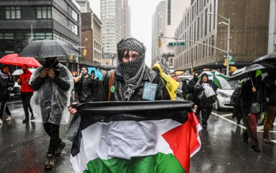 متضامنة ترفع العلم الفلسطيني في مظاهرة_