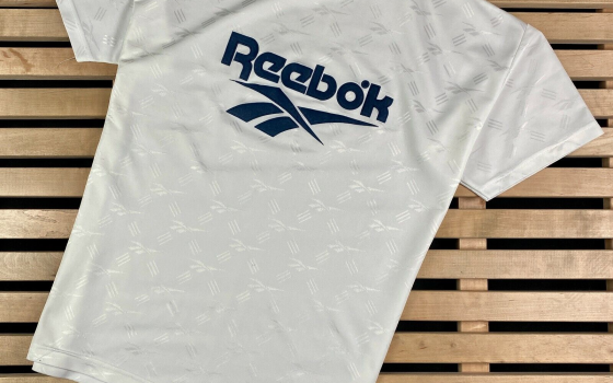 قميص يحمل شعار ريبوك