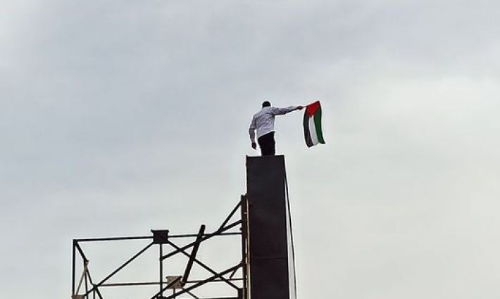 شاب مصري تسلّق لوحة إعلانية في إحدى مناطق الإسكندرية حاملًا العلم الفلسطيني