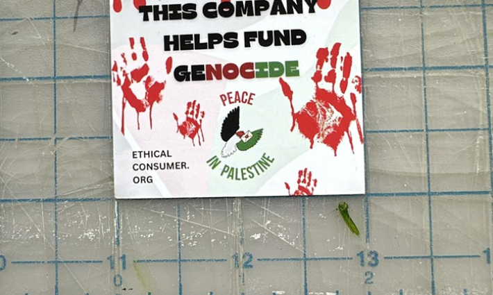 لافتة كتب عليها: هذه الشركة تدعم الإبادة