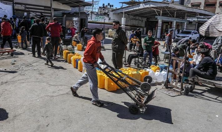 طفل يحاول الحصول على حصة من الماء خلال الحرب