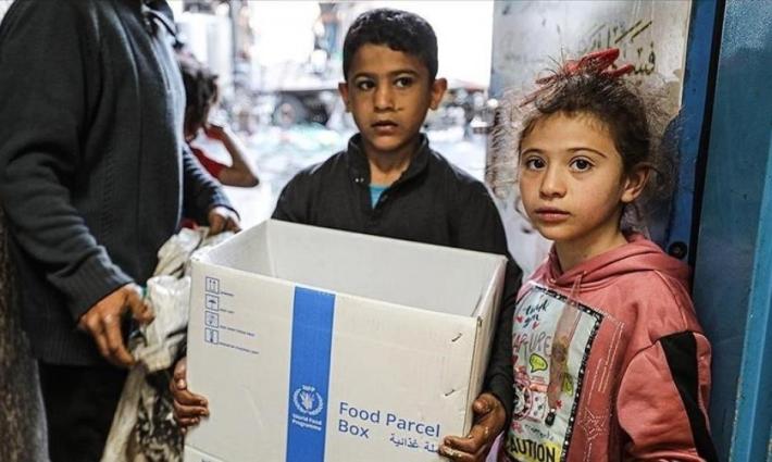 طفل يحمل صندوق مساعدات غذائية في غزة