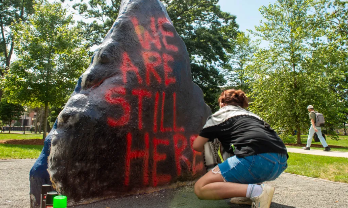 صخرة في جامعة كونيتيكت مكتوب عليها  we are still here
