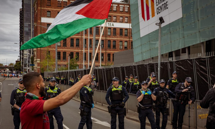 متظاهر يرفع علم فلسطين في مظاهرة داعمة لفلسطين