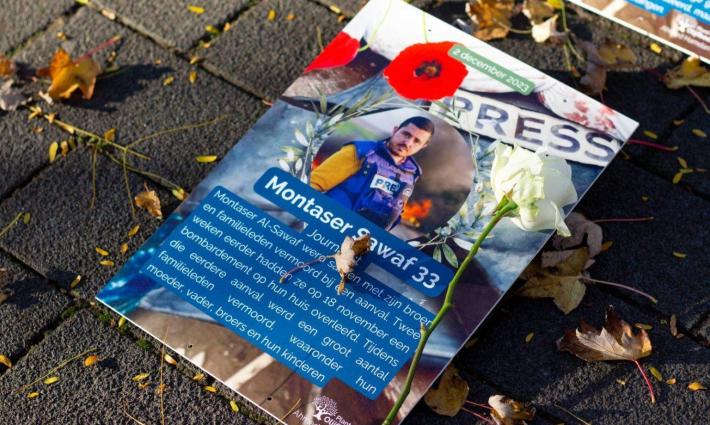 ورقة تحمل صورة صحفي استشهد في غزة