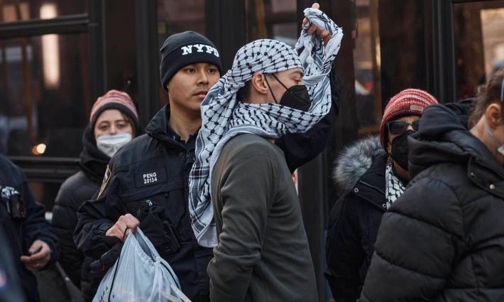 متضامن مع فلسطين يرتدي كوفية