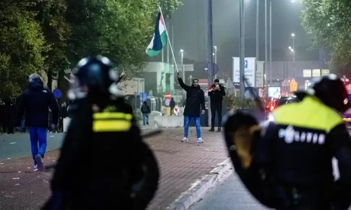 متظاهر يحلم علم فلسطين في أمستردام
