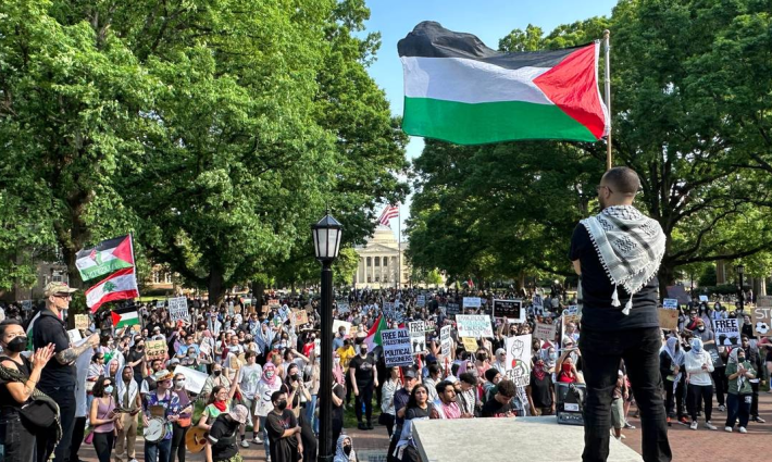 طالب يحمل العلم الفلسطيني في تحرك داعم لفلسطين