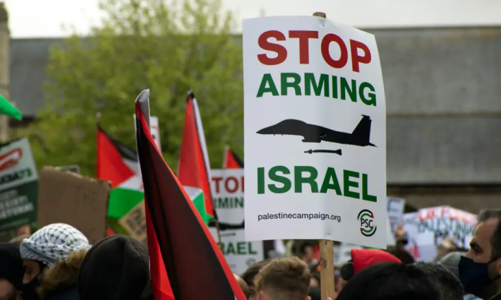 لافتة تدعو لوقف تسليح الاحتلال