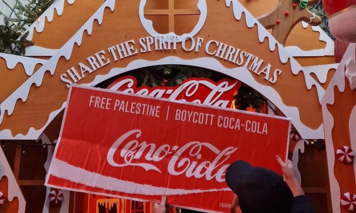 لافتة تدعو لحرية فلسطين منددة بتواطؤ كوكاكولا بدعم الاحتلال