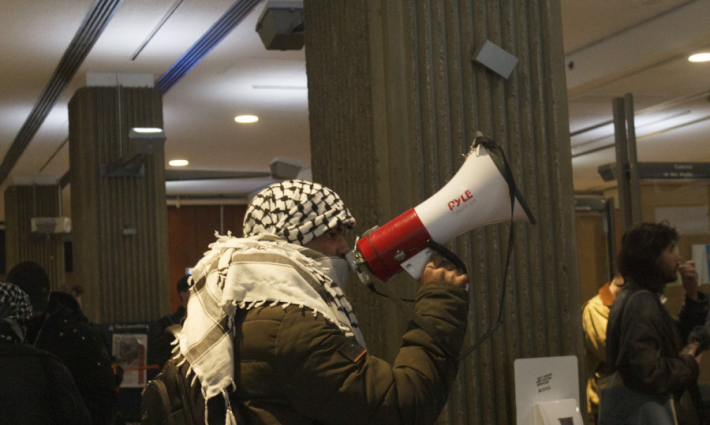 طالب داعم لفلسطين يستخدم مكبر صوت ليهتف بشعارات تضامنية