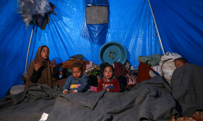 أطفال ووالدتهم في غزة في خيمة نزوح