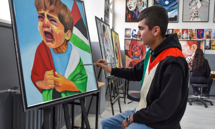 طالب يرسم لوحة عن فلسطين