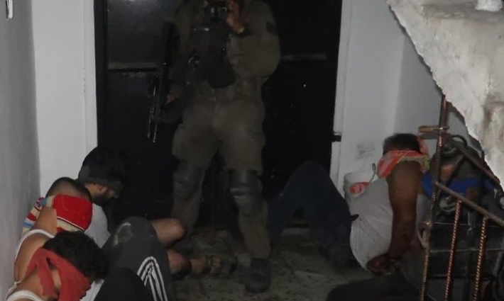 جندي إسرائيلي يعتقل مدنيين من غزة