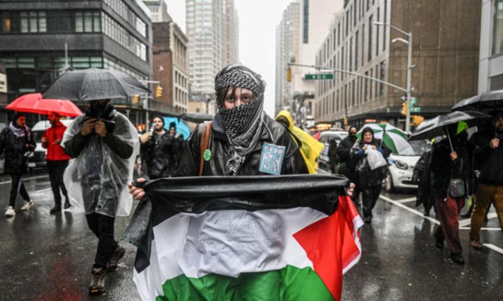 متضامنة ترفع العلم الفلسطيني في مظاهرة_