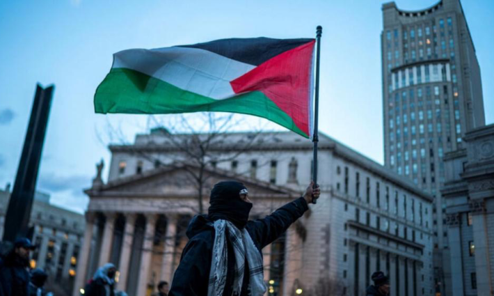 متضامن يرفع العلم الفلسطيني في إيطاليا